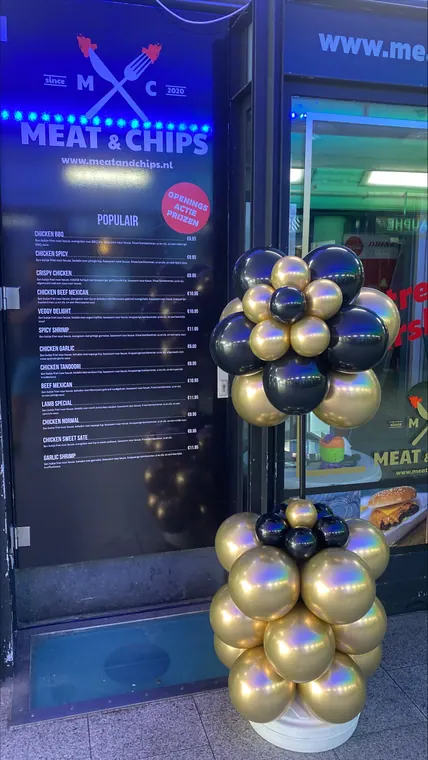Goudkleurige en donkere ballonpilaar bij een entree