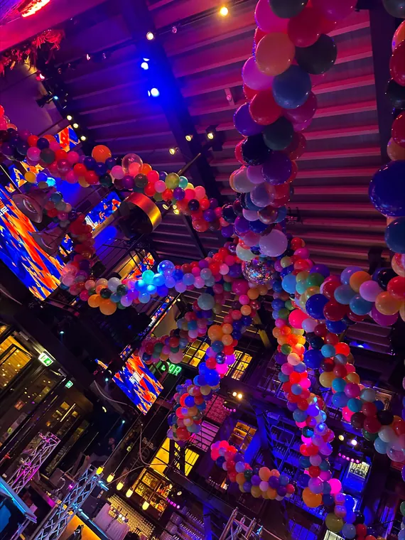 Kleurrijke ballondecoratie boven een feestzaal