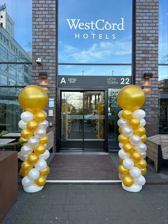Wit-gouden ballonpilaren bij een hotelentree