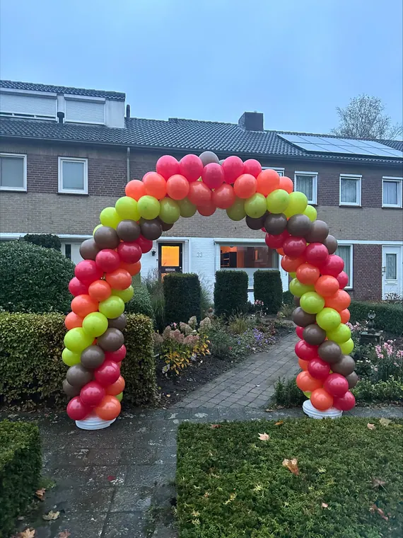 Kleurrijke ballonboog bij een woning