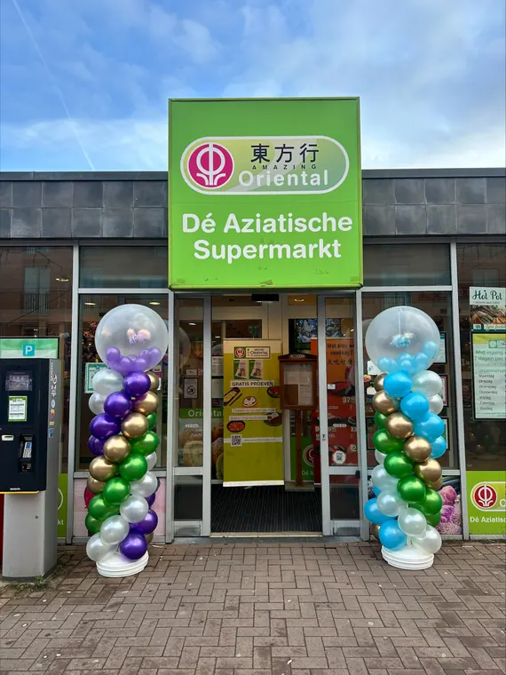 Kleurrijke ballonpilaren bij een winkelopening