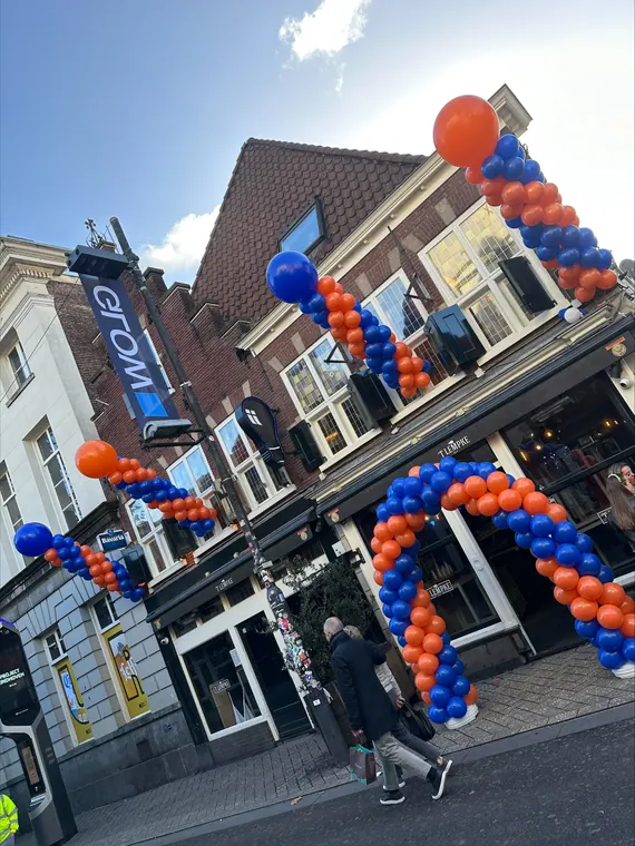 Blauw-oranje ballonboog aan een gevel