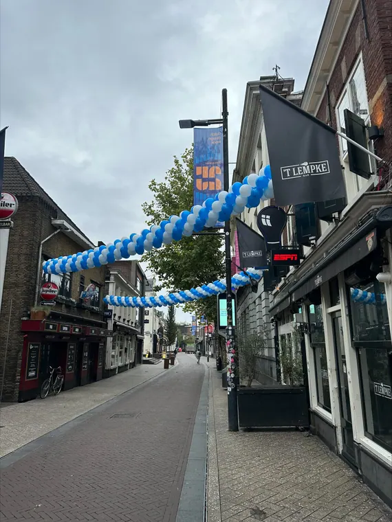 Blauwe ballonguirlande langs een straat
