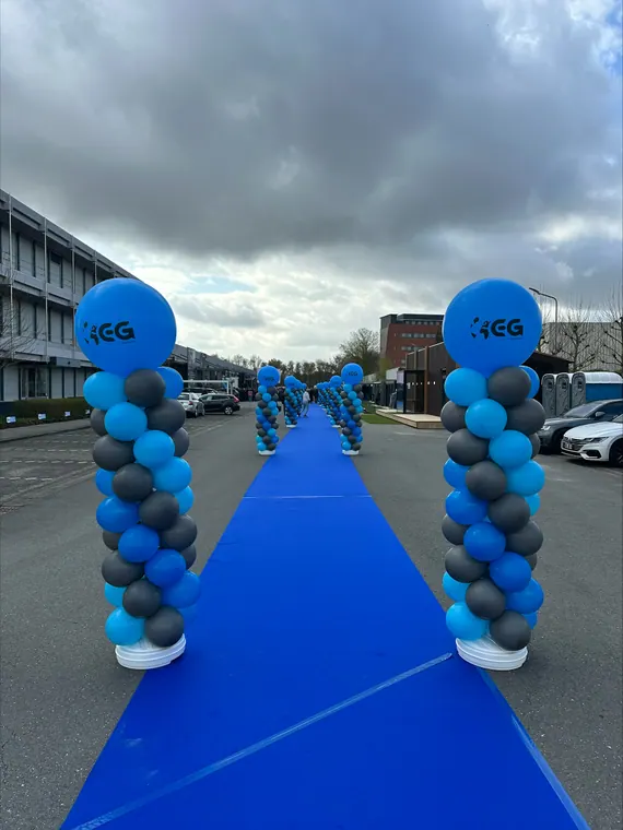 Blauwe ballonpilaren langs een loper