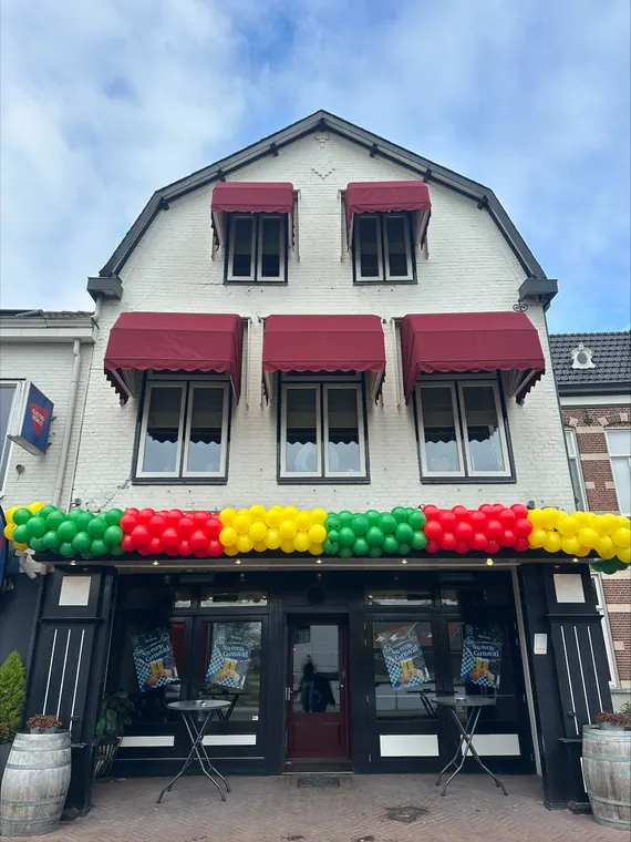 Kleurrijke ballondecoratie aan een winkelgevel