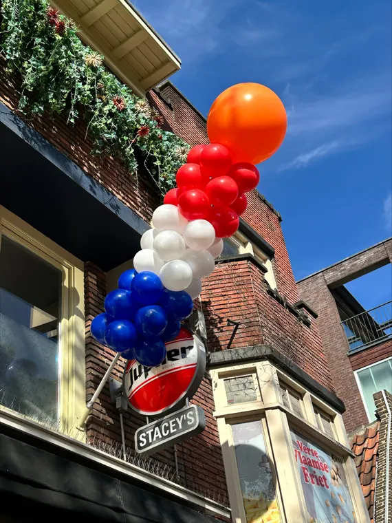 Vrolijk ballonfiguur bij een winkel