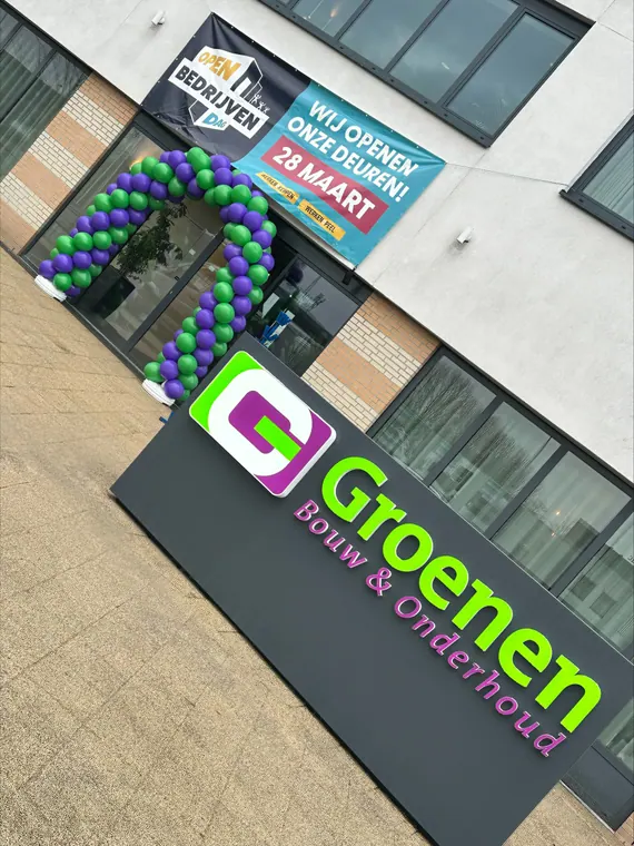 Groene en blauwe ballondecoratie aan een winkelgevel